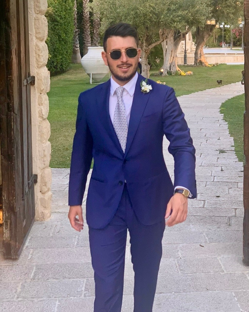 best-man-in-a-blue-suit-standing-outdoors-on-a-stone-path-with-greenery