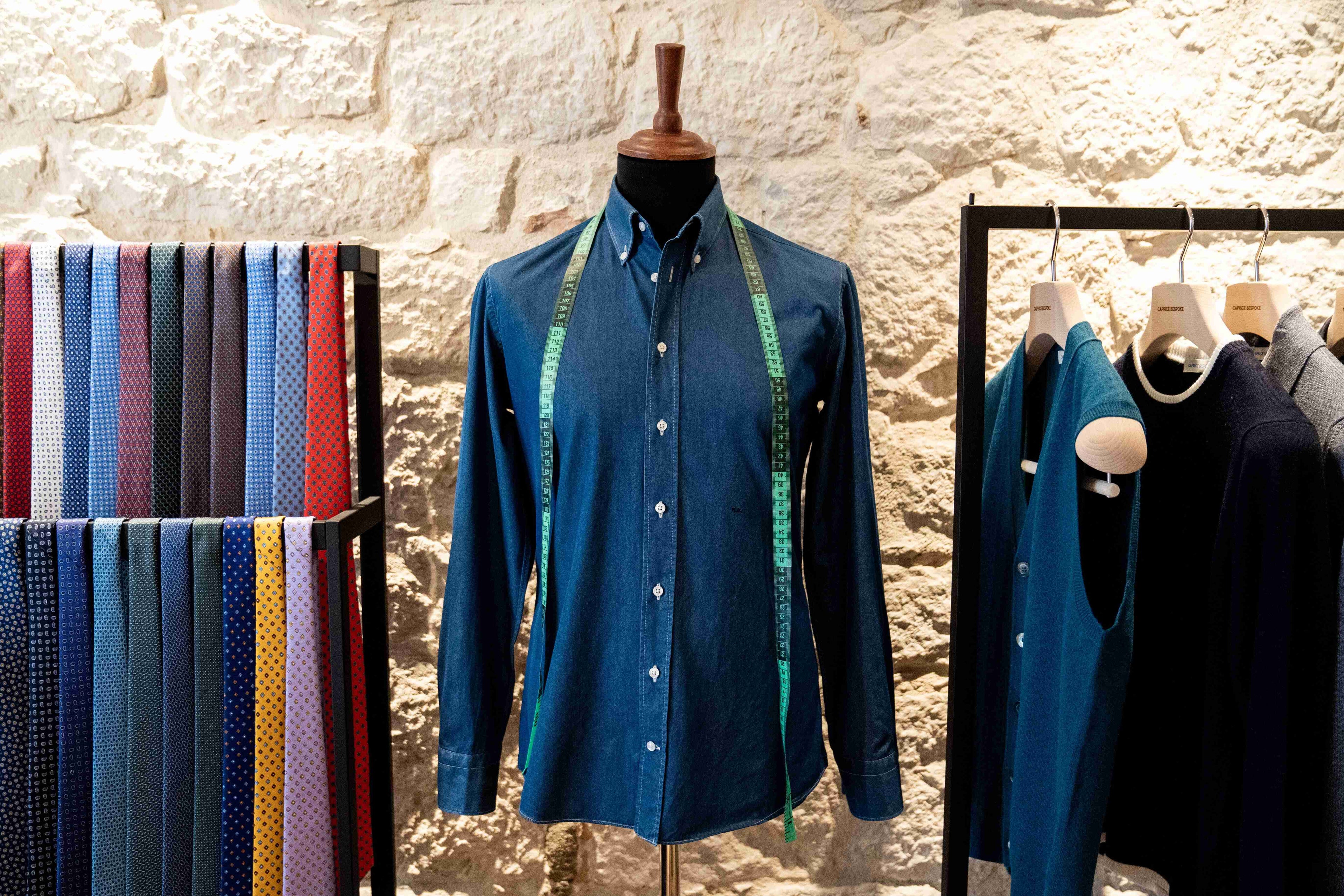 custom-made-shirt-with-tailoring-tools-silk-ties-and-knitwear-on-hangers-at-caprice-bespoke-atelier-in-campobasso