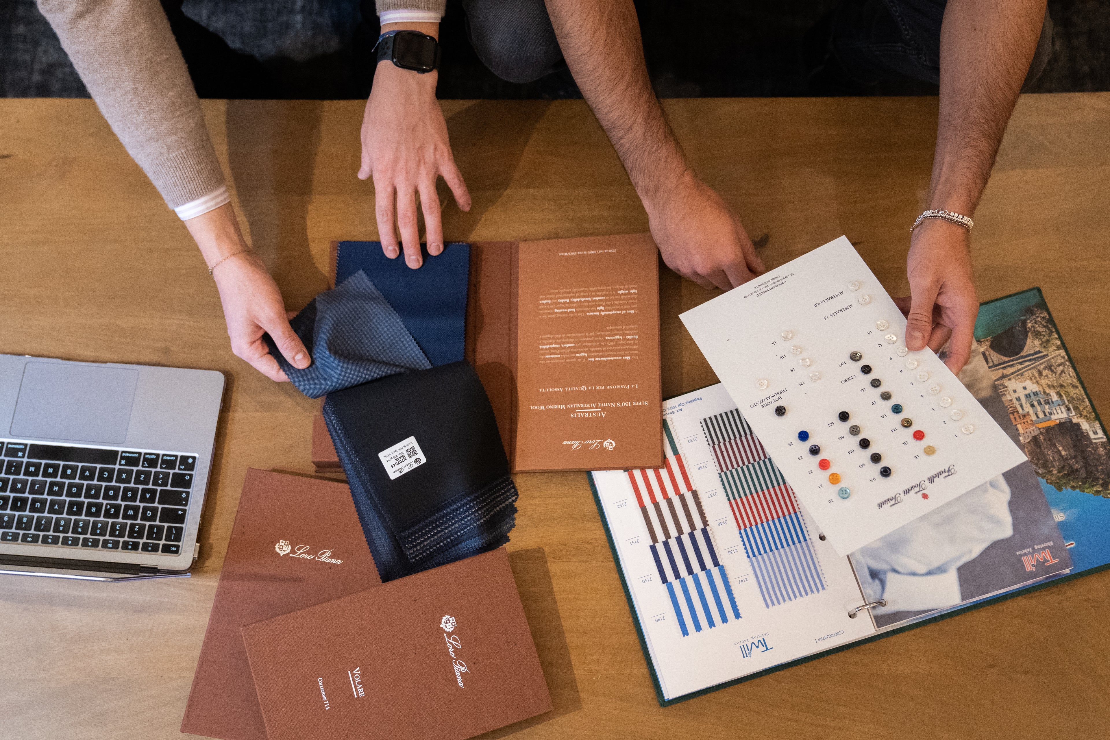 personal-stylist-showing-fabrics-to-customer-during-private-tailor-appointment